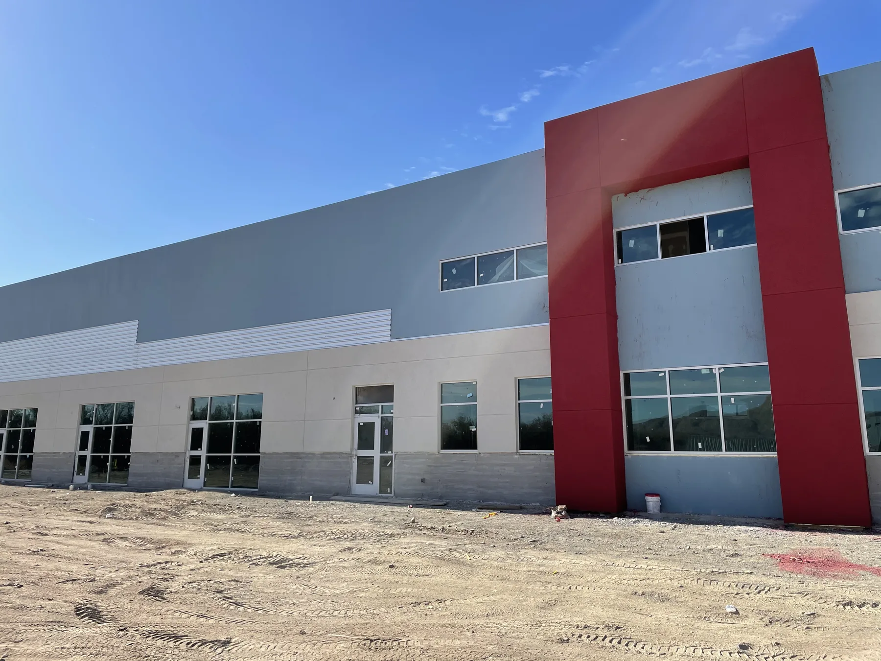 Finished two-storey Appaloosa Business Complex in white and grey with a tall red entry tower