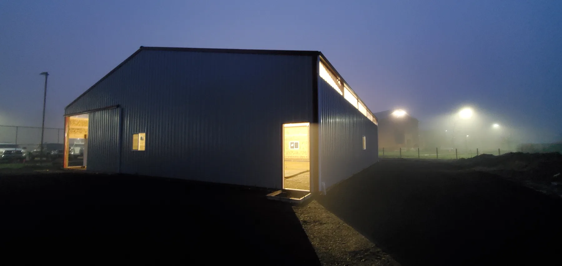 Completed Chemawa pole barn exterior at night, lit from inside